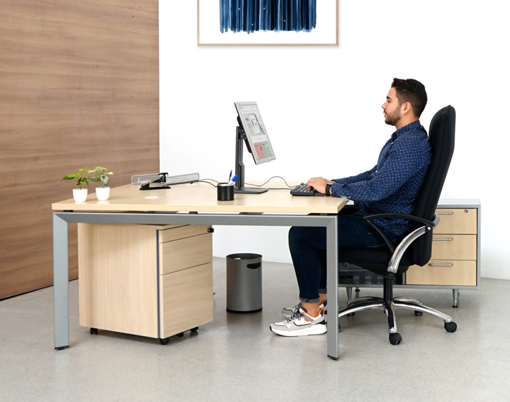 Mesa Angular para oficinas Doue de Steelcase con cajonera y armario podría considerarse como una opción clásica en la que sus medidas 160cm x 160 cm y forma de L permiten colocar el ala a derechas o izquierdas, de tal manera que se pueden incluso juntar dos puestos de trabajo. En su cometido de atención a cliente, la mesa Doue de Steelcase facilita la comunicación directa con el cliente, tiene espacio suficiente para manejar documentos o catálogos e incluso girar el monitor del ordenador. Esta mesa tiene integrados dos zonas de almacenaje muy prácticas, cajonera metálica y armario metálico totalmente integrados en la estructura que permite acopiar o archivar documentos, catálogos, fichas de producto, etc. El armario de puerta batiente tiene un tirador metálico para facilitar su apertura y en su interior, alberga un estante metálico negro regulable en altura, y apto para carpetas colgantes. El tablero de melamina de la mesa Doue tiene forma angular o también conocida popularmente como forma de ola y un color característico de Steelcase llamado bahía y que se asemeja al color arce. Además, la mesa de oficina Doue de Steelcase viene dotada con 3 aberturas pasacables para mantener ordenados los antiestéticos cables de los dispositivos electrónicos. Sin lugar a dudas una opción, eficiente, robusta y con una estética muy polivalente que encaja en cualquier espacio de trabajo